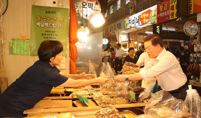 박승원 광명시장이 지난 2024년 9월 추석 명절을 앞두고 새마을 전통시장을 찾아 광명사랑화폐로 상품을 구매하고 있다.