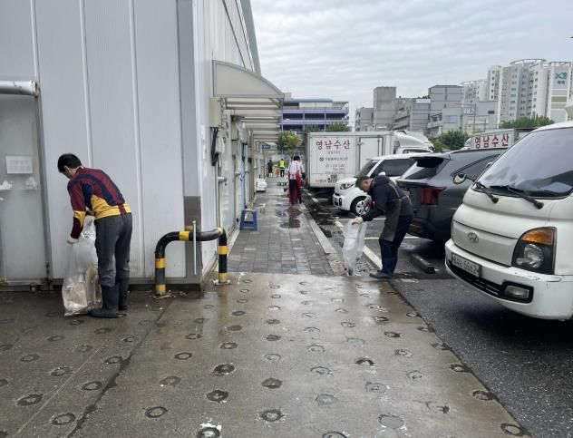 수원시농수산물도매시장에서 공직자, 상인들이 함께 대청소를 하고 있다.