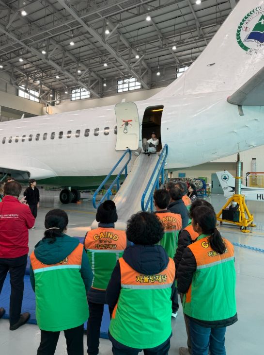 청양군 지역자율방재단 단원들이 한서대학교 재난안전교육원에서 항공기 비상탈출 체험교육을 받으며 실제 상황에 대비한 안전훈련을 실시하고 있다