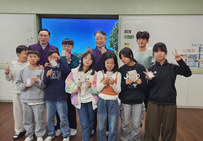 선비교사와 함께 단체 사진을 찍고 있는 어린이들