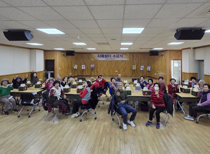 2025년 치매 쉼터 프로그램 수료식에 참여한 어르신, 보호자, 직원들이 기념촬영을 하고 있다.