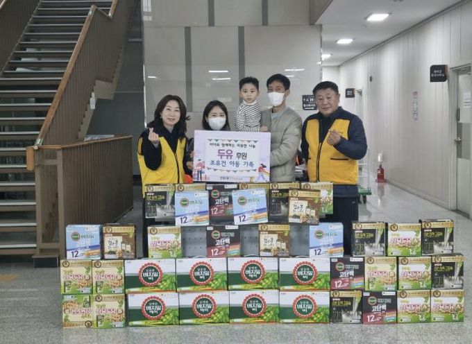 조유건 아동 가족이 두유 등 후원 물품을 전달하고 기념촬영을 하고 있다.
