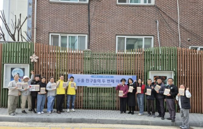 아산시 온양3동 주민자치회 위원 및 전시 참여 학부모들이 담장 갤러리에서 작품 교체 작업을 진행하고 있다.