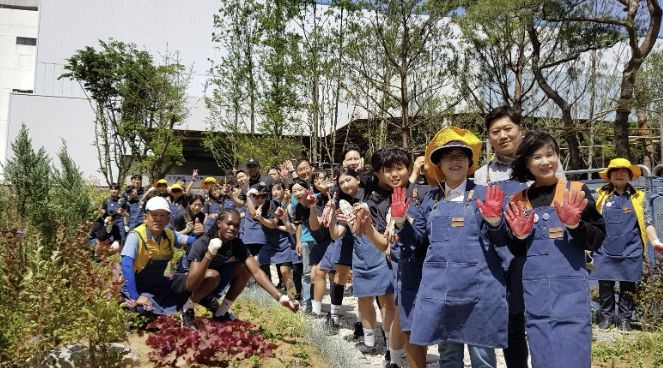 2024년 5월 수원FC위민 선수를 비롯한 참가자들이 손바닥정원 조성 후 기념촬영을 하고 있다.